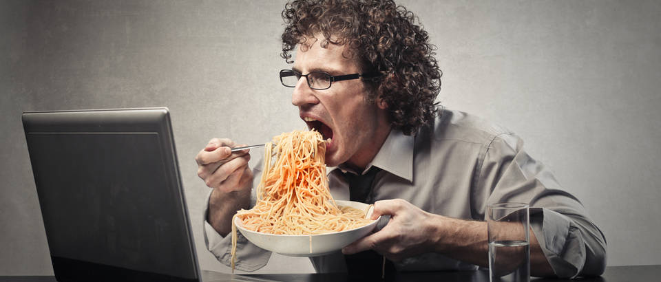 Jesti za radnim stolom računalo špagete apetit shutterstock 335742551
