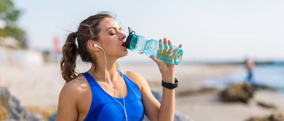 Voda žeđ žena ljeto plaža sport trčanje boca slušalice glazba shutterstock 434900977